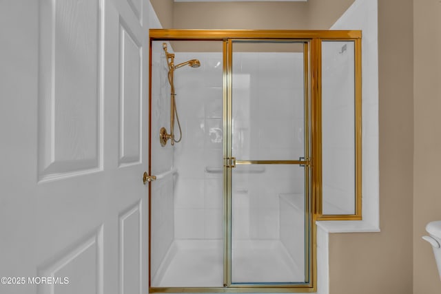 full bath featuring a shower stall and toilet
