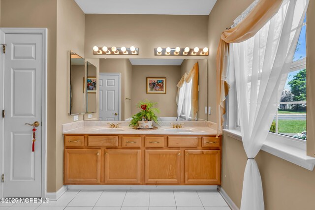 bathroom featuring double vanity, baseboards, and tile patterned flooring