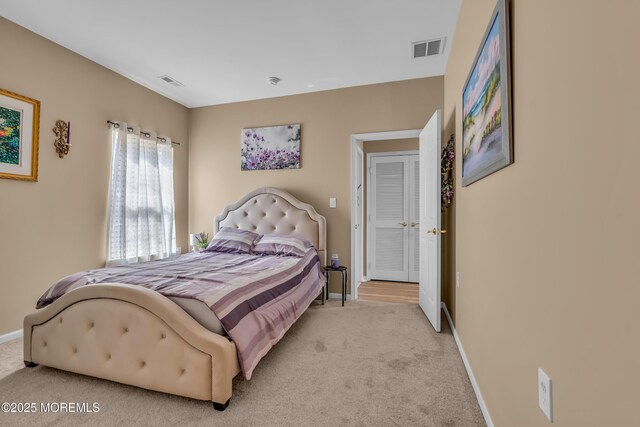 bedroom featuring light colored carpet and baseboards
