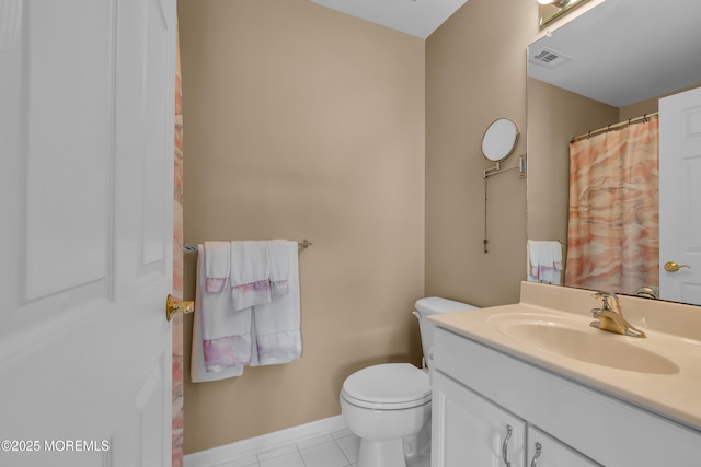 bathroom with toilet, vanity, tile patterned floors, and baseboards