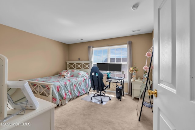 carpeted bedroom with a desk