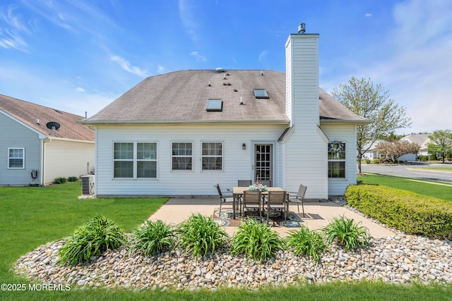 rear view of property with a patio, a lawn, a chimney, and cooling unit