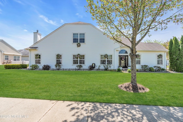 view of front of house with a front yard and a chimney