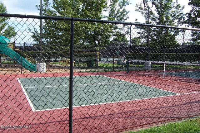 view of tennis court featuring fence