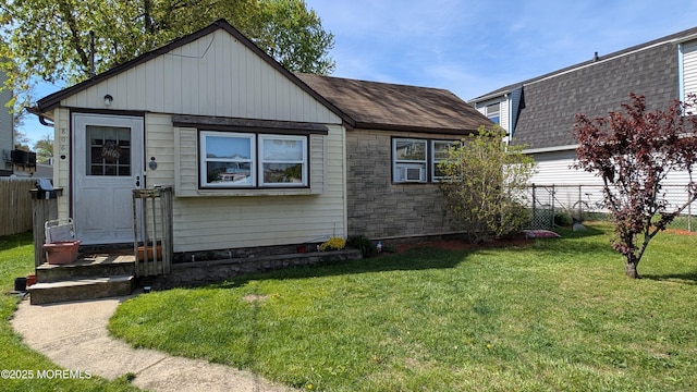 back of house featuring a lawn, roof with shingles, fence, and cooling unit