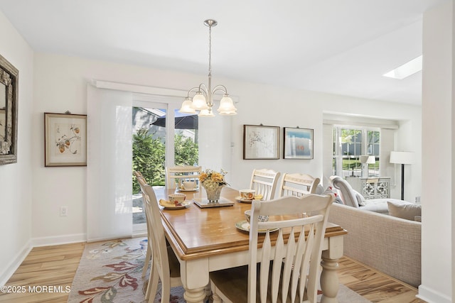90 Oak Ln, Eatontown, NJ 07724 - dining room with light wood finished floors, a chandelier, a skylight, and baseboards