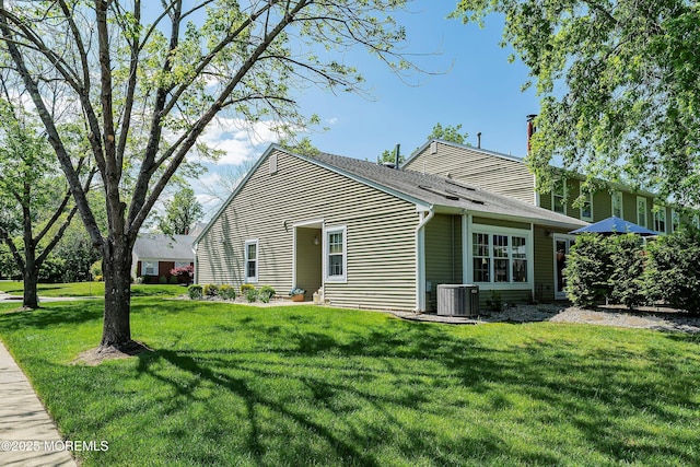 90 Oak Ln, Eatontown, NJ 07724 - view of front of house featuring central AC unit, a chimney, and a front lawn