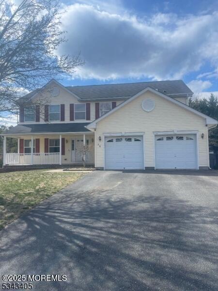 view of front facade with driveway, covered porch, and an attached garage