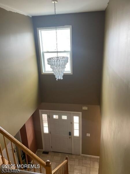 entrance foyer with stairway, an inviting chandelier, and a wealth of natural light