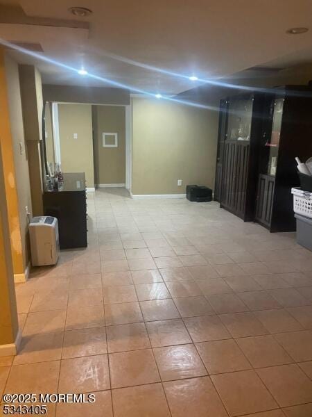 finished basement with light tile patterned floors and baseboards