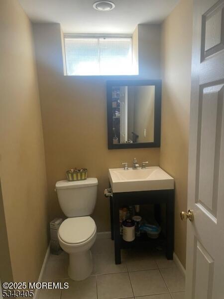 bathroom featuring vanity, toilet, baseboards, and tile patterned floors