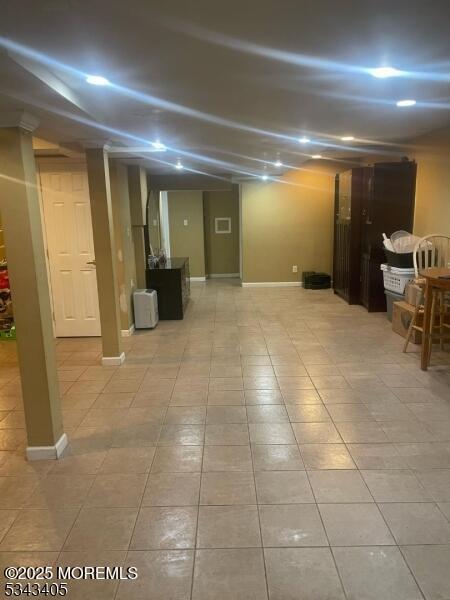 below grade area featuring tile patterned flooring and baseboards