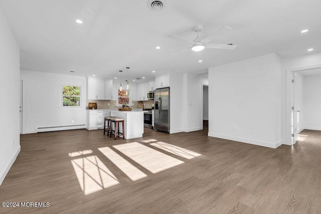 living area featuring dark wood finished floors, a baseboard radiator, recessed lighting, and visible vents