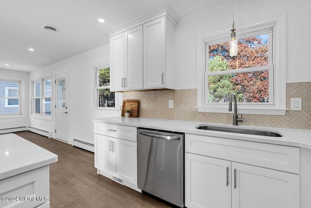 kitchen featuring tasteful backsplash, stainless steel dishwasher, baseboard heating, a sink, and white cabinetry
