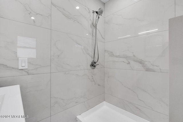 bathroom with a marble finish shower