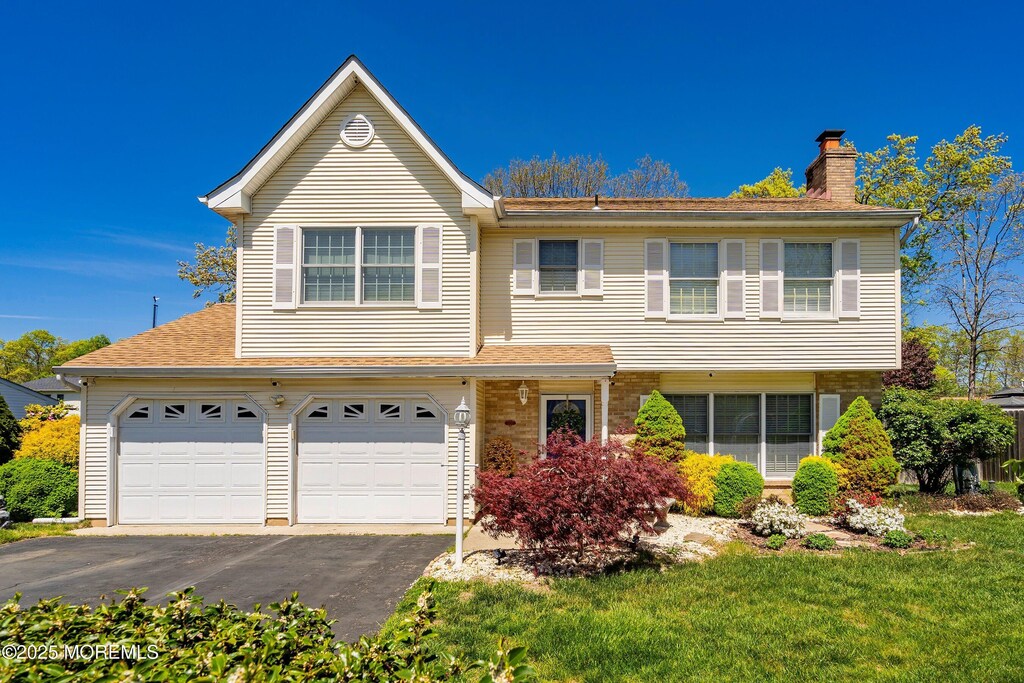 8 Independence Way, Howell, NJ 07731 - view of front of property featuring an attached garage, a shingled roof, aphalt driveway, and a chimney