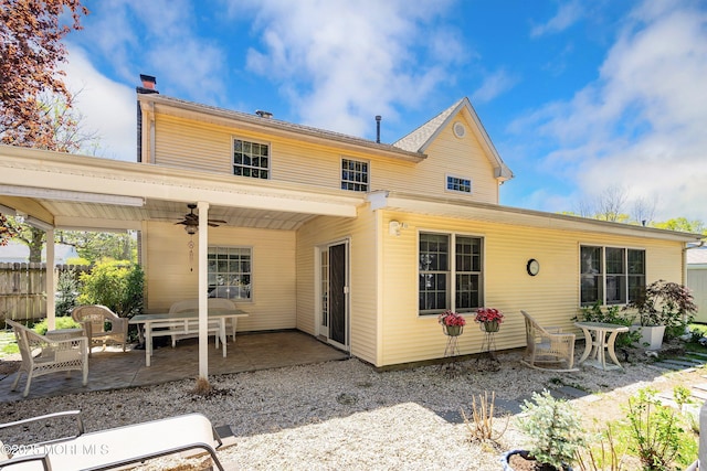 back of house with fence, a patio, ceiling fan, and a chimney