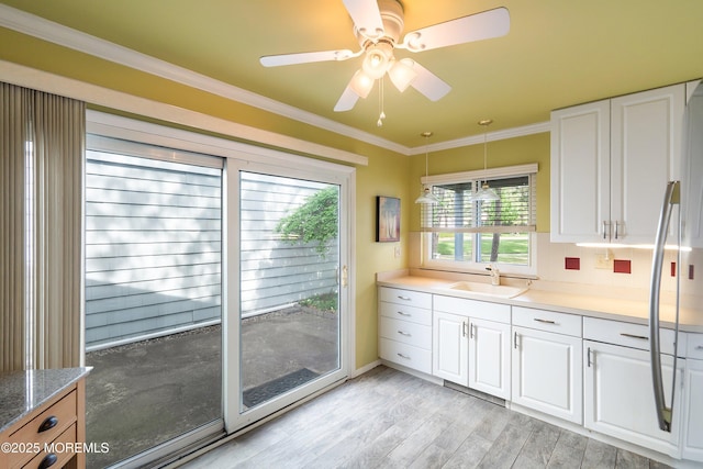 436A New Castle Ct, Manchester, NJ 08759 - kitchen featuring a sink, crown molding, light wood-style flooring, and white cabinetry