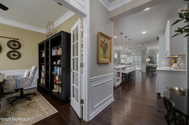 office with a wainscoted wall, ornamental molding, a decorative wall, and dark wood finished floors