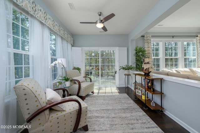 sunroom / solarium with baseboards, visible vents, and wood finished floors