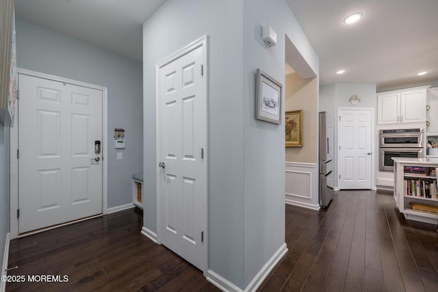 hallway featuring dark wood-style flooring, baseboards, and recessed lighting