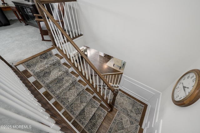 staircase with a wainscoted wall