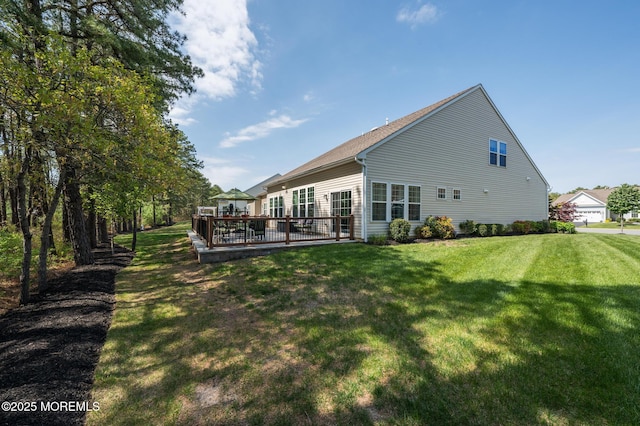 back of property with a lawn and a wooden deck