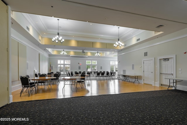 misc room featuring crown molding, a raised ceiling, a chandelier, and visible vents