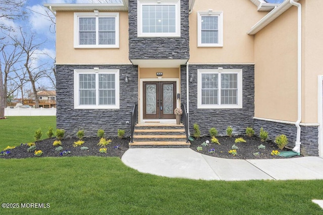 property entrance featuring french doors, stone siding, and stucco siding