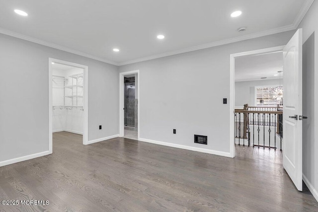 empty room with baseboards, ornamental molding, and wood finished floors