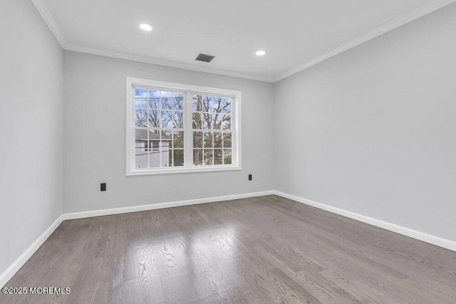spare room featuring visible vents, wood finished floors, baseboards, ornamental molding, and recessed lighting