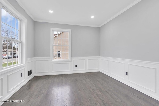 empty room featuring crown molding, recessed lighting, dark wood-style flooring, and a wainscoted wall