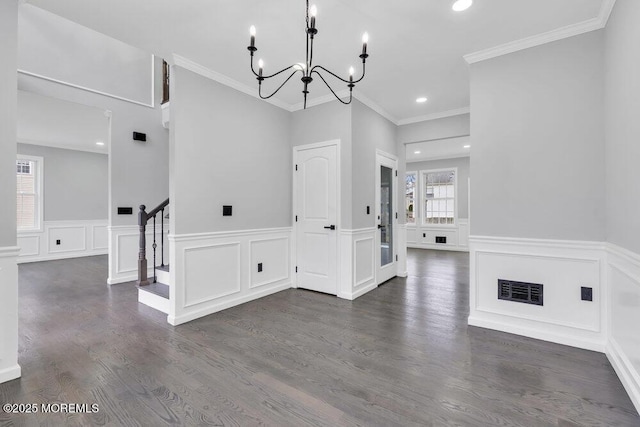 interior space featuring an inviting chandelier, visible vents, a decorative wall, stairway, and a wainscoted wall