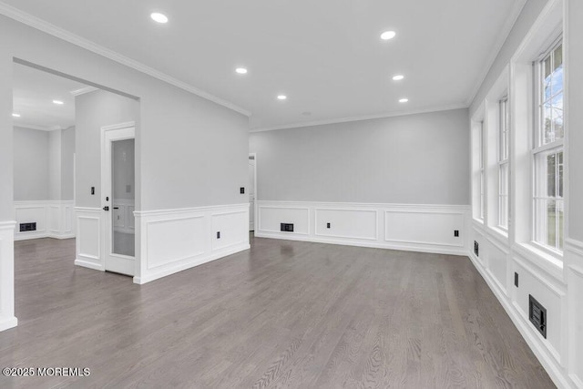 unfurnished room featuring crown molding, recessed lighting, wainscoting, and wood finished floors
