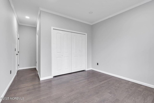 unfurnished bedroom featuring baseboards, ornamental molding, a closet, and wood finished floors