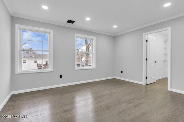 spare room featuring crown molding, visible vents, and wood finished floors