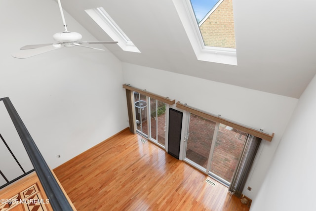 interior space featuring a skylight, ceiling fan, plenty of natural light, and wood finished floors