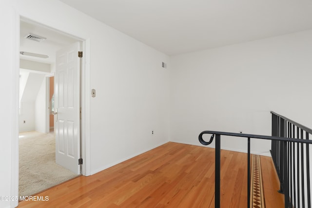 interior space with light wood-style floors, baseboards, and visible vents