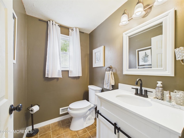 bathroom with toilet, tile patterned flooring, vanity, and baseboards