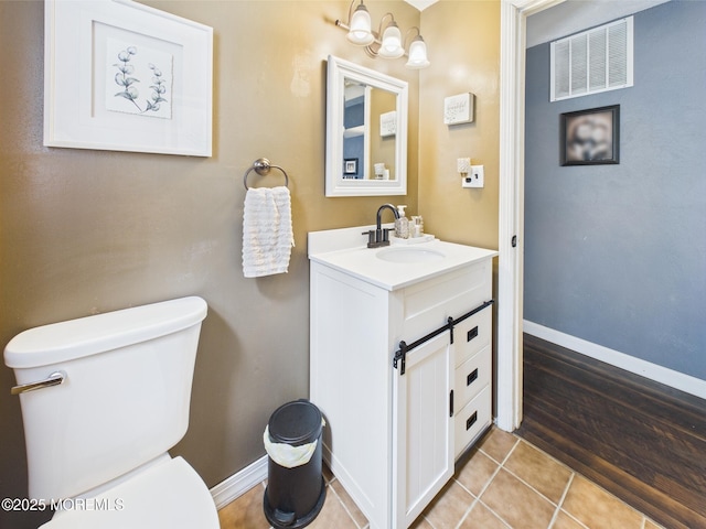 bathroom with toilet, vanity, tile patterned floors, and baseboards