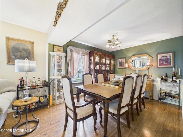 dining space with a chandelier and wood finished floors