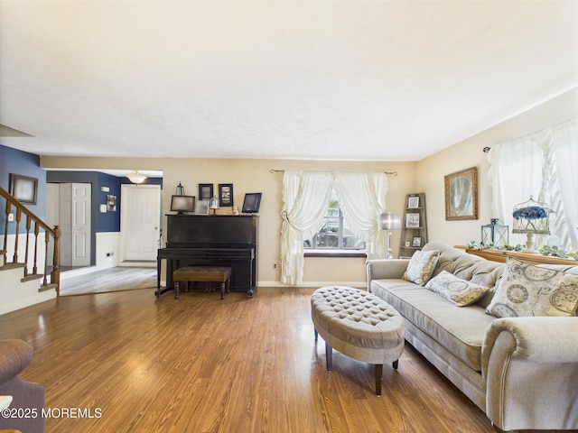 living room featuring wood finished floors, stairs, and baseboards