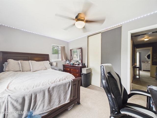 bedroom featuring a closet, light carpet, and ceiling fan
