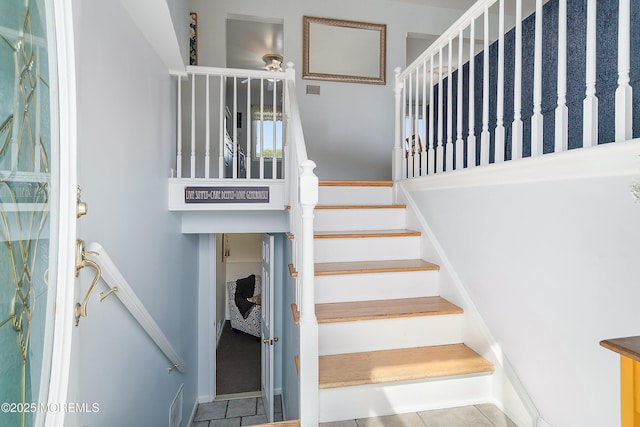staircase with tile patterned floors and ceiling fan