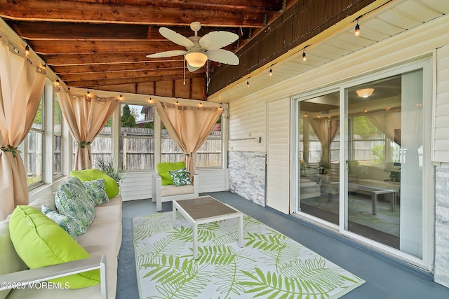 sunroom / solarium with ceiling fan, rail lighting, outdoor lounge area, and beam ceiling