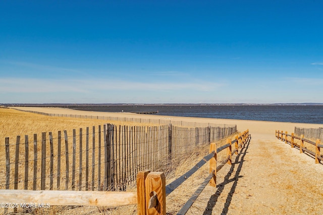 water view featuring fence and nearby beach