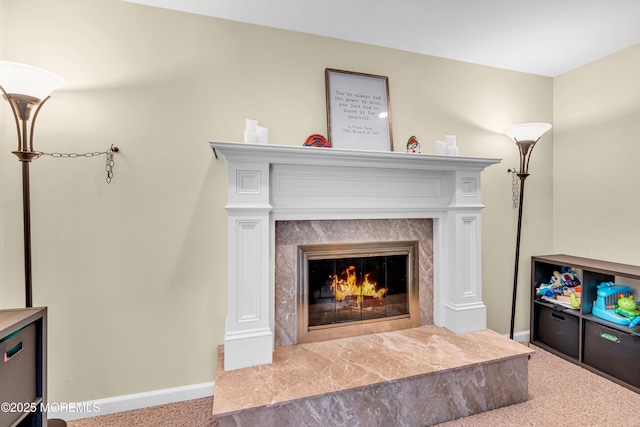 detailed view of carpet floors, a high end fireplace, and baseboards