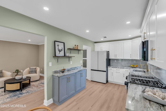 6 Reef Pl, Brick, NJ 08723 - kitchen with freestanding refrigerator, a sink, light wood-type flooring, white cabinetry, and light stone counters