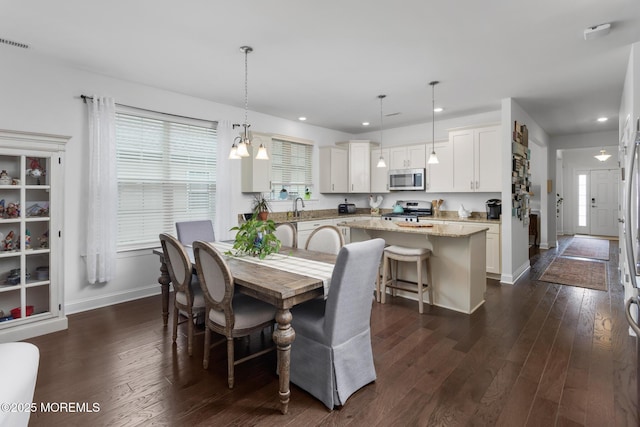 dining space with recessed lighting, dark wood-style floors, baseboards, and healthy amount of natural light
