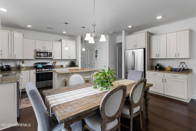 dining area with recessed lighting, dark wood-type flooring, and a chandelier